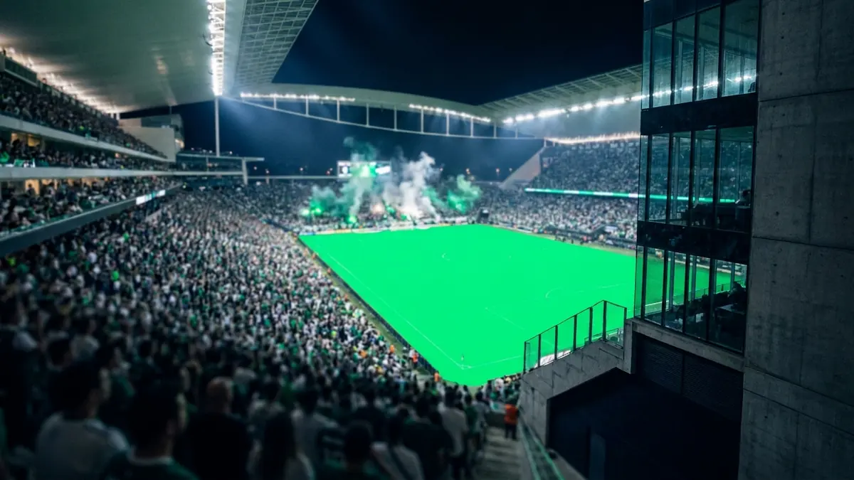 Arquibancada lotada em verde e branco numa arena moderna de São Paulo à noite, com o gramado iluminado ao fundo.